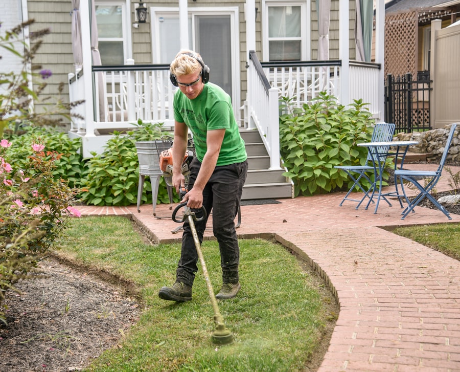 Landscaper edging a lawn with a trimmer